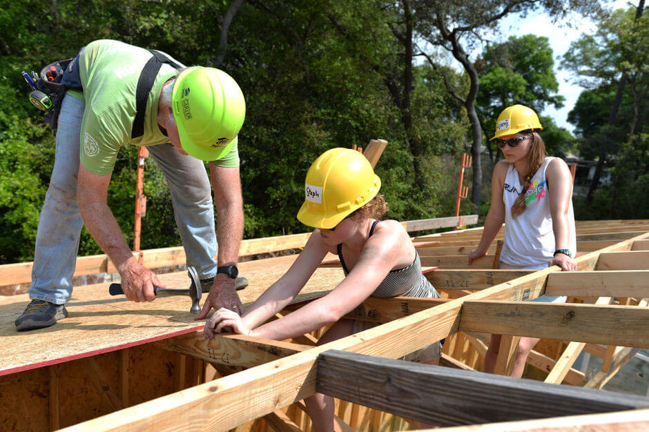 volunteers working on roof at construction site