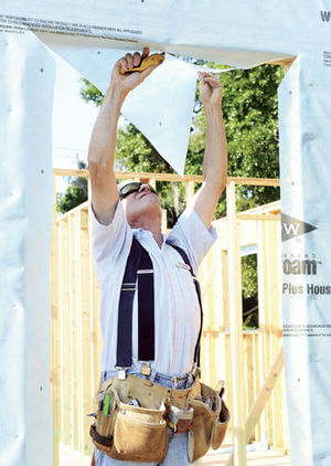 volunteer working on windows at a construction site