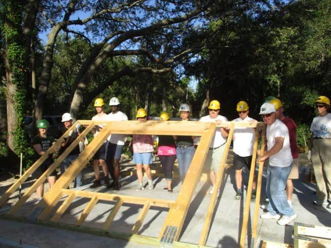 volunteers raising a wall